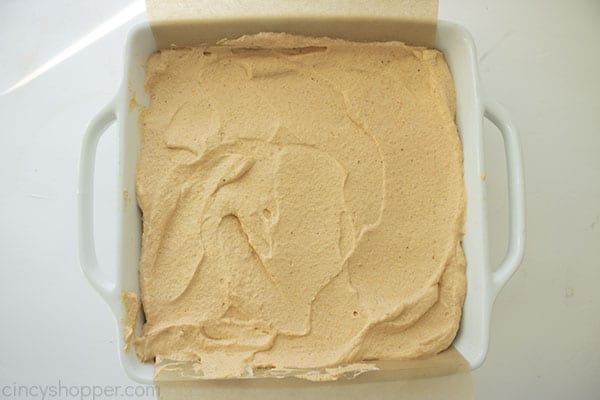 Overhead shot of the final and top layer of the Pumpkin Icebox Cake in a white square pan on a white background