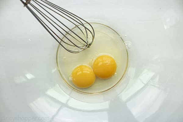 Eggs in a clear bowl with whisk