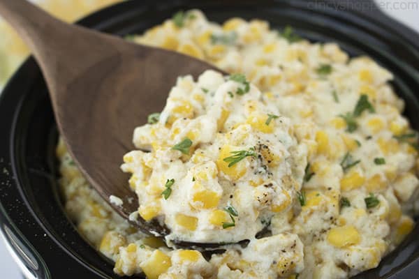 Slow cooker corn on a wooden spoon