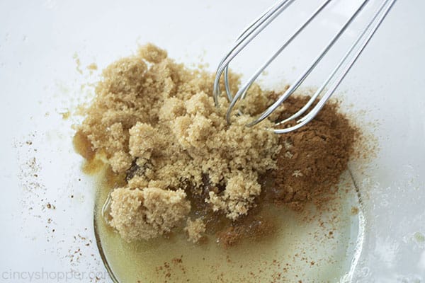 Sugar and spice mixture in a clear bowl with a whisk