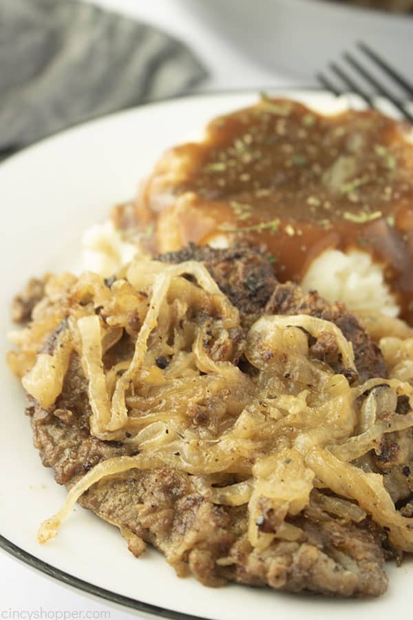Moms liver and onions on a plate with mashed potatoes and gravy.