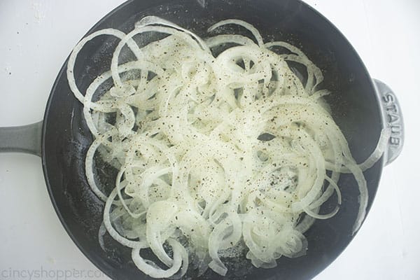 onions cooking in a dark pan.