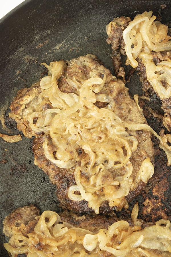 Beef liver and onions in a dark pan.