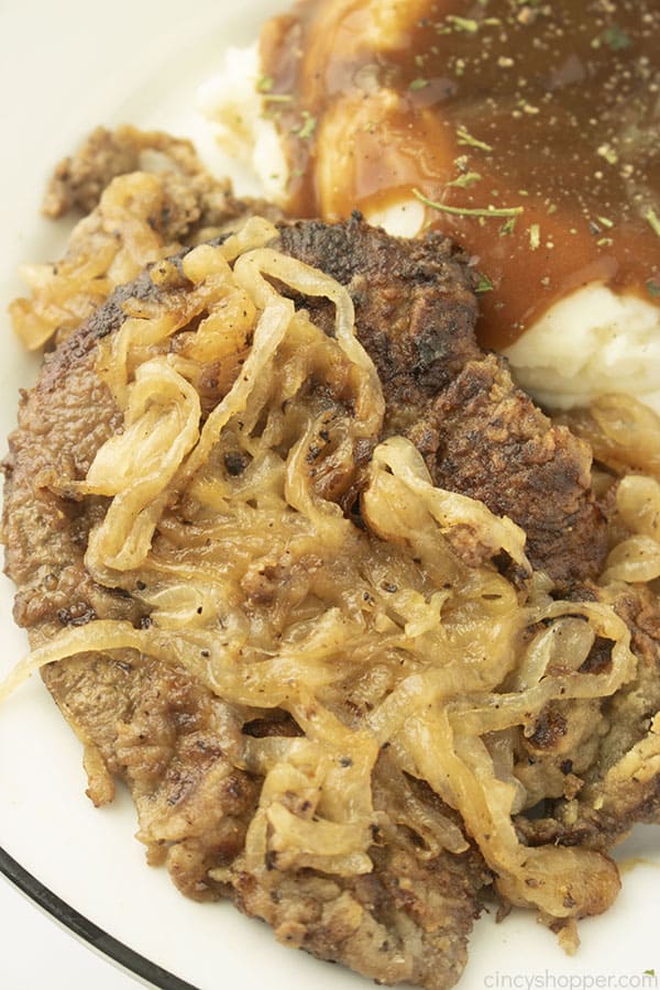 Old Fashioned Liver and Onions on a plate with mashed potatoes and gravy.