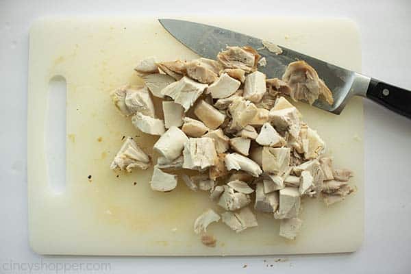 Diced chicken on a cutting board with a knife