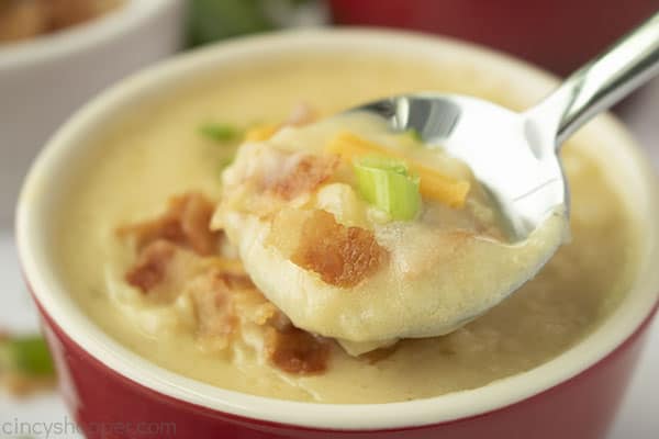 Potato soup with toppings on a spoon