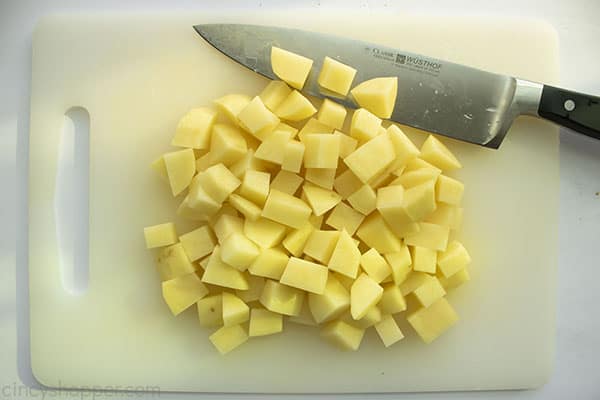 Diced potatoes on a cutting board with a knife