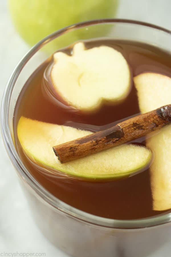 Clear mug with apple cider and floating fruit