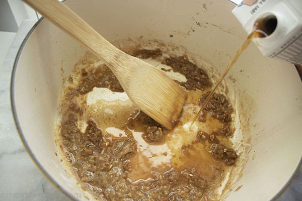 Beef broth being added to onion roux