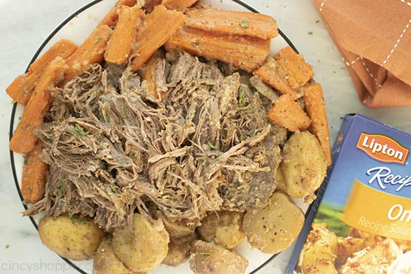 Finished pot roast on a plate with carronts and potatoes