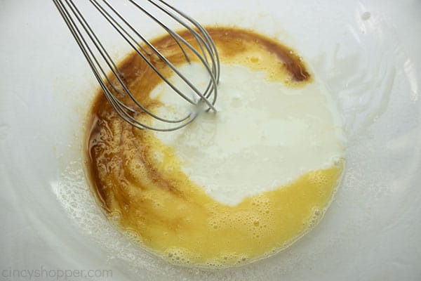 Wet mixture in clear bowl with whisk