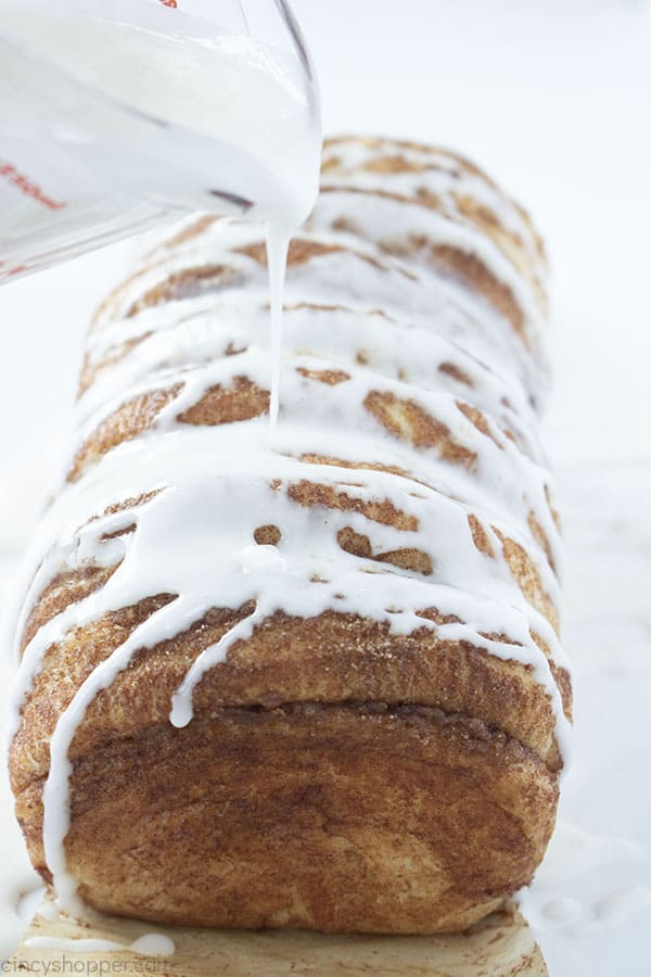 Glaze being poured on to the cinnamo bread