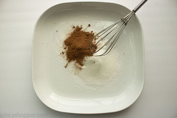 Cinnamon suagr mixture ina white bowl with whisk