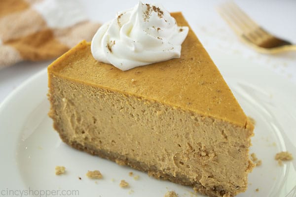 Slice of Pumpkin Cheesecake with whipped cream on a plate