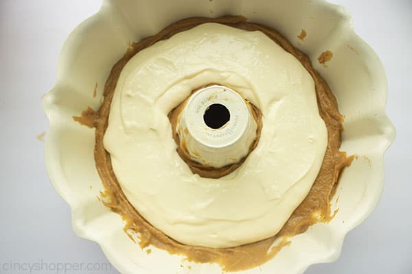 Cream cheese filling layer added over the top of pumpkin cake layer.