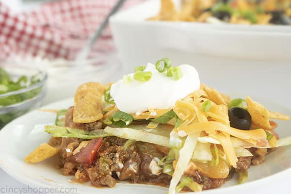 Taco casserole on a white plate with toppings