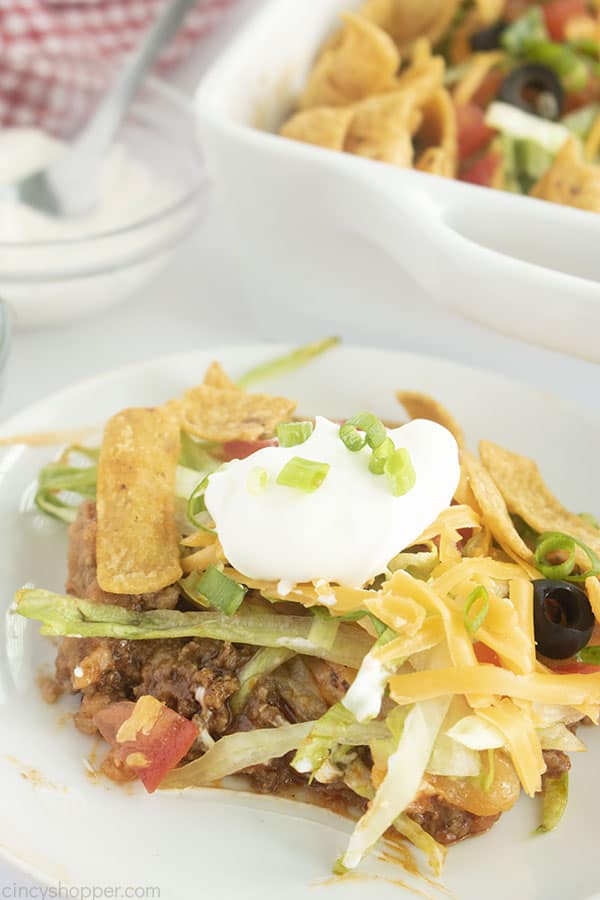 Serving of Mexican casserole on a plate with sour cream on top.