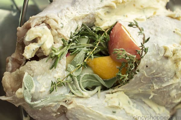 Adding apples, lemon and herbs to the inside of turkey