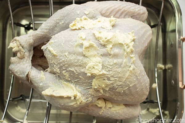 Lathering herb butter on Thanksgiving Turkey