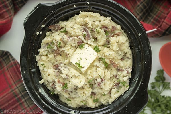 Finished mashed potatoes with butter and parsley on top.