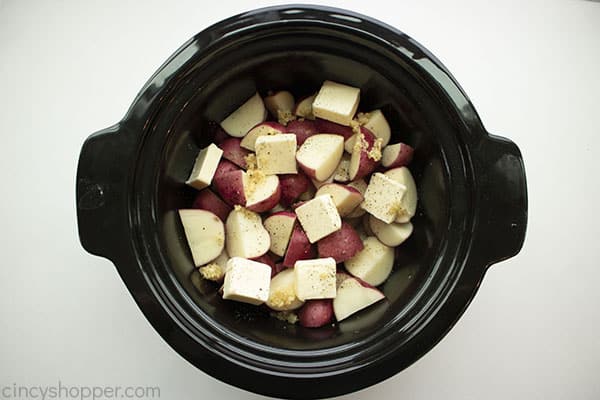 Potatoes, butter, minced garlic, and salt & pepper in slow cooker