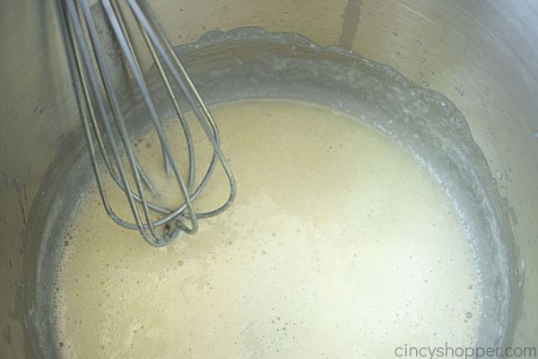 Whisking creamy parmesan cheese sauce