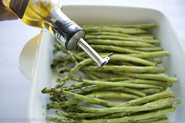 Drizzling olive oil on asparagus 
