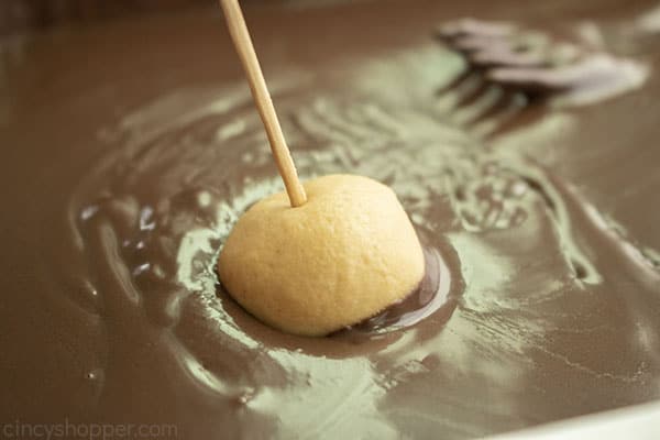 Dipping the peanut butter candy in chocolate