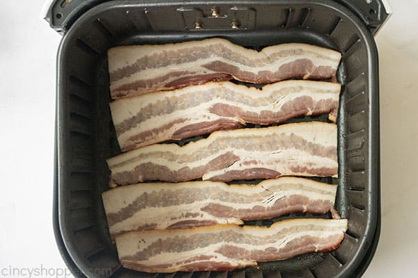 Raw bacon in air fryer basket