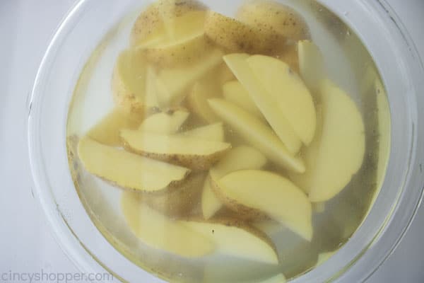 Soaking potato wedges in water and salt