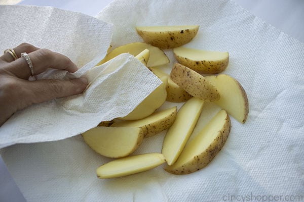 Patting dry potatoes slices 