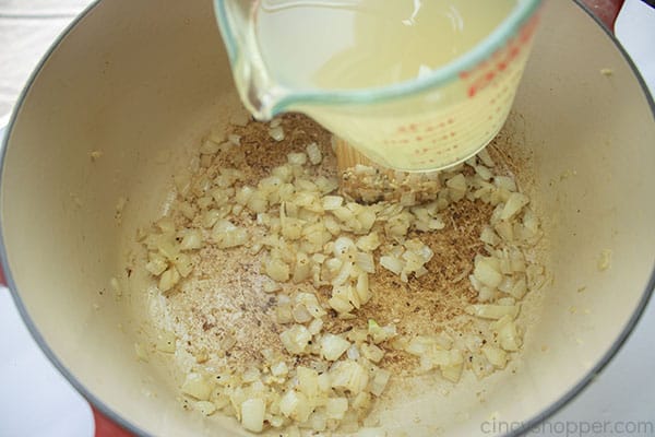 Adding broth to onions and garlic