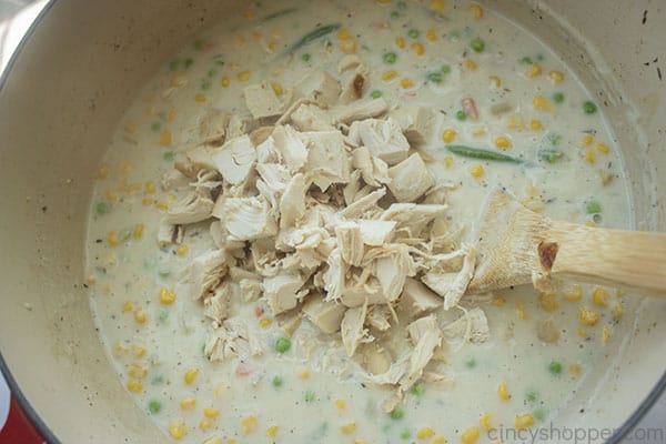 Adding chicken to creamy soup
