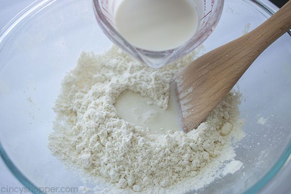 Adding milk mixture to dry biscuit ingredients