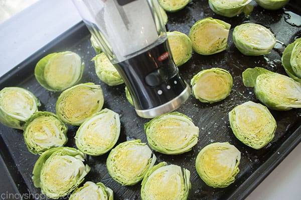 Salt added to sprouts on sheet pan