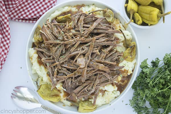 Tender Pot roast shredded on top of mashed potatoes with gravy
