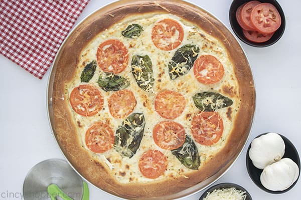 Fresh baked white pizza with basil and tomatoes 