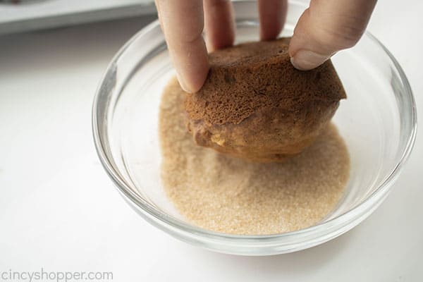 Dipping muffin in cinnamon sugar