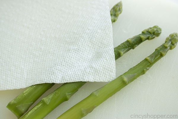 Patting asparagus dry with paper towel