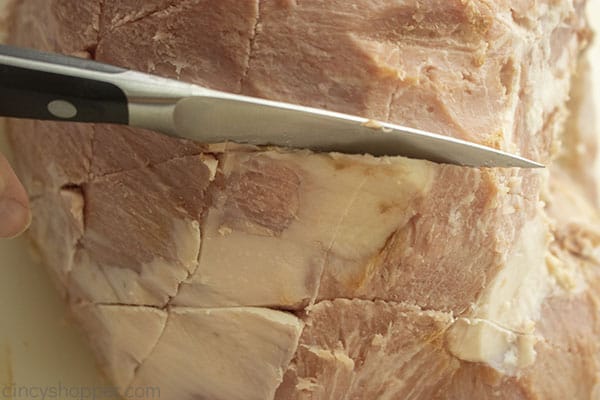 Slicing whole ham with diamond pattern
