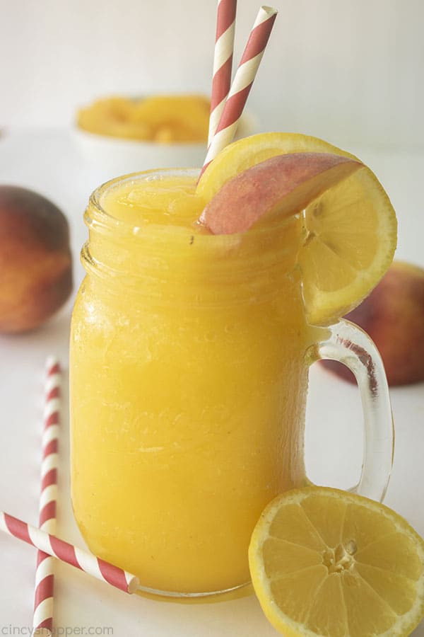 Frozen Peach Lemonade in a glass with straws