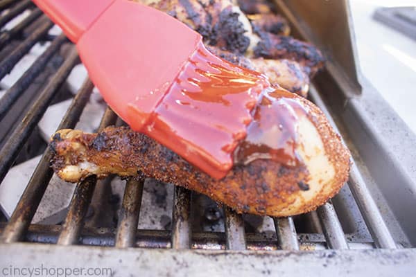 Brushing barbeque chicken with sauce 