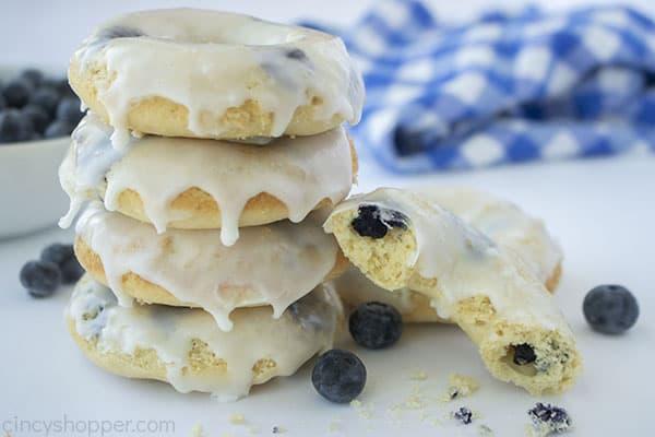 Stack of blueberry donuts and one broken open