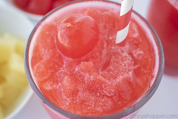 Cherry slush with straw and a cherry