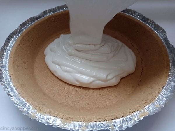 Poring lemonade pie mix into crust