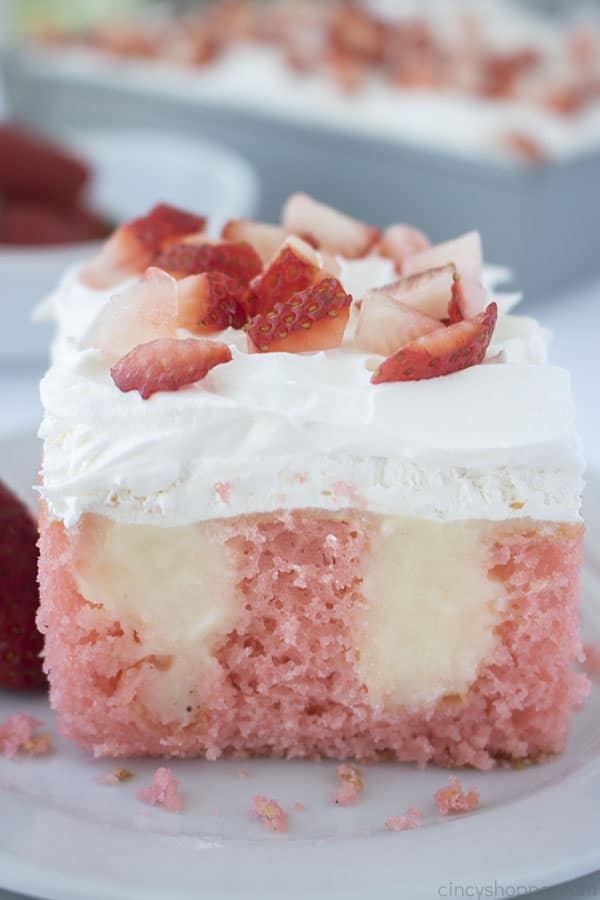 Strawberry Cheesecake Poke Cake on a plate