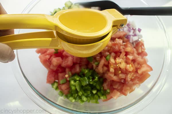 Fresh lime squeezed on top of salsa ingredients