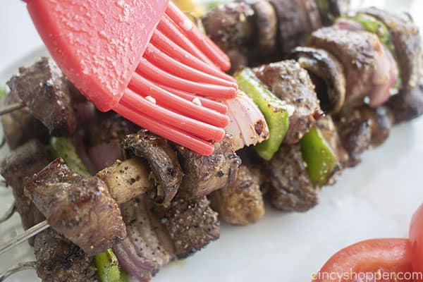 Brushing garlic butter on grilled Steak Kebabs