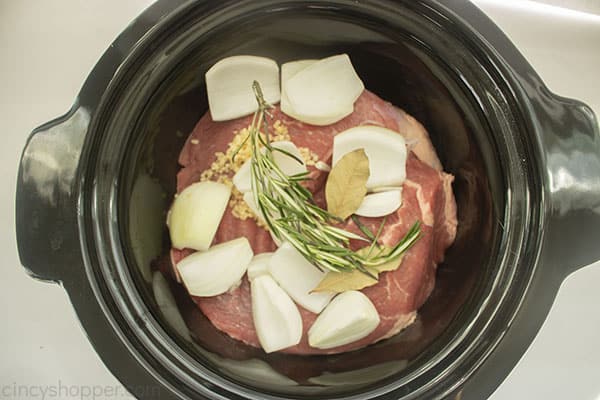 Roast, onions, spices in slow cooker for French Dip