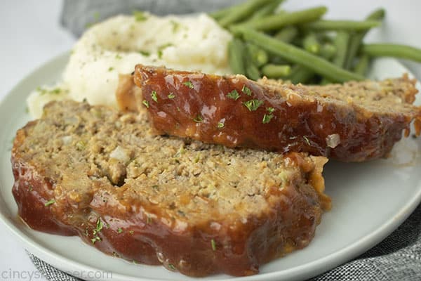 Copycat Cracker Barrel Meatloaf on a plate with mashed potatoes green beans